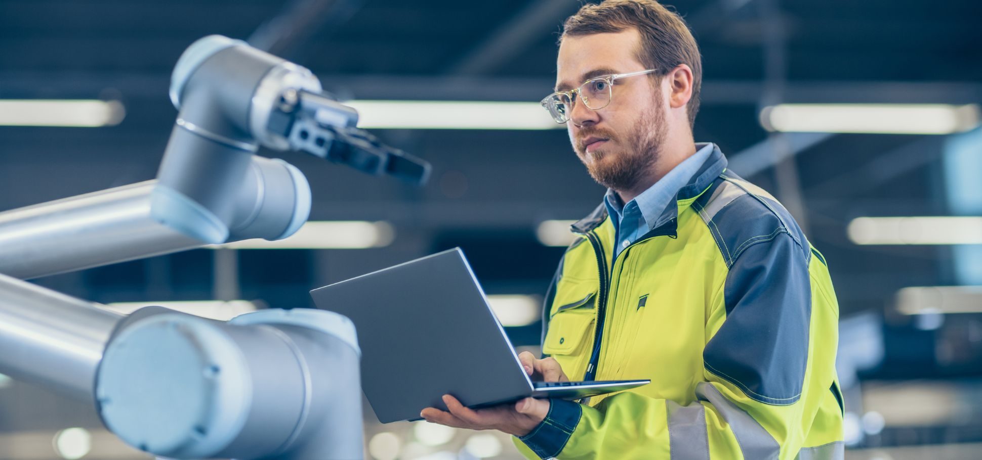 Man working in a manufacturing plant on his laptop