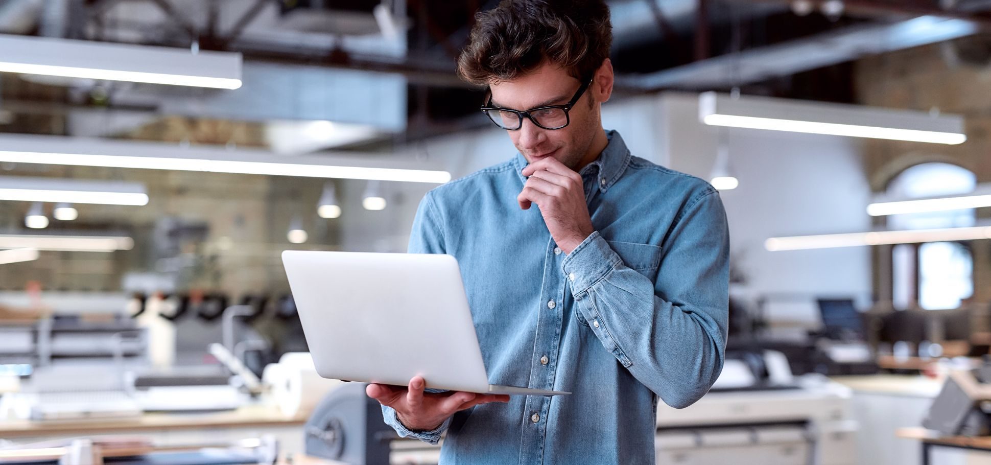 Man works on a laptop in an industrial building