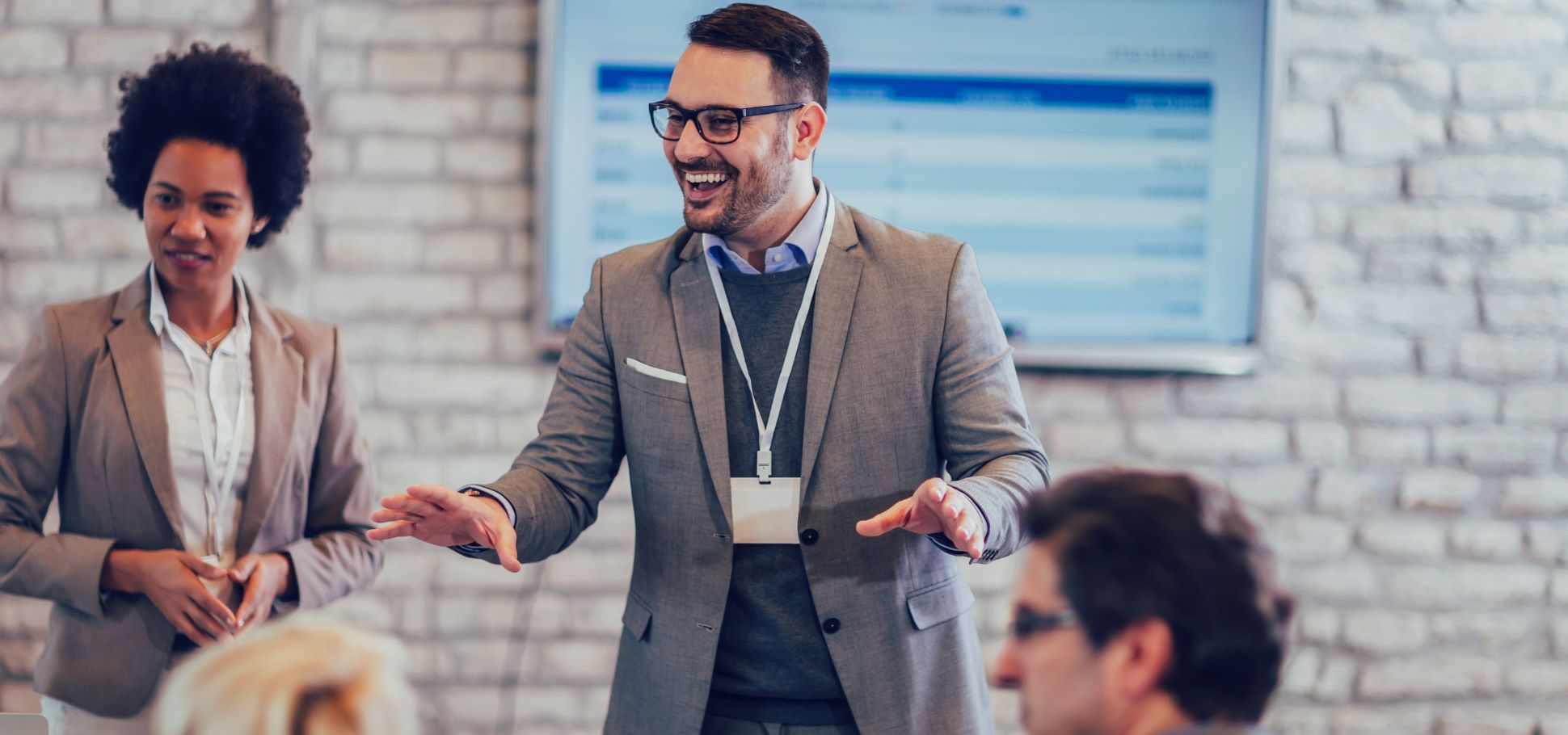 Man gestures with his hands amongst his colleagues