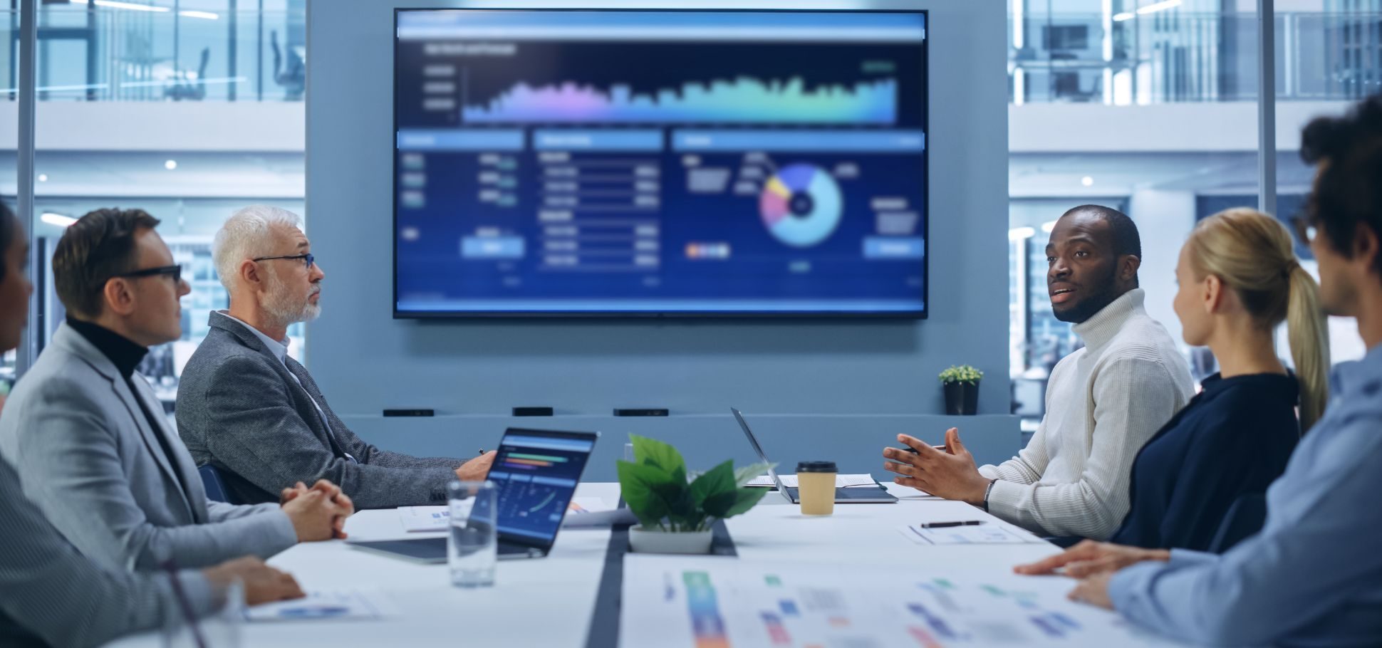 Co-workers gather around a conference table to discuss data