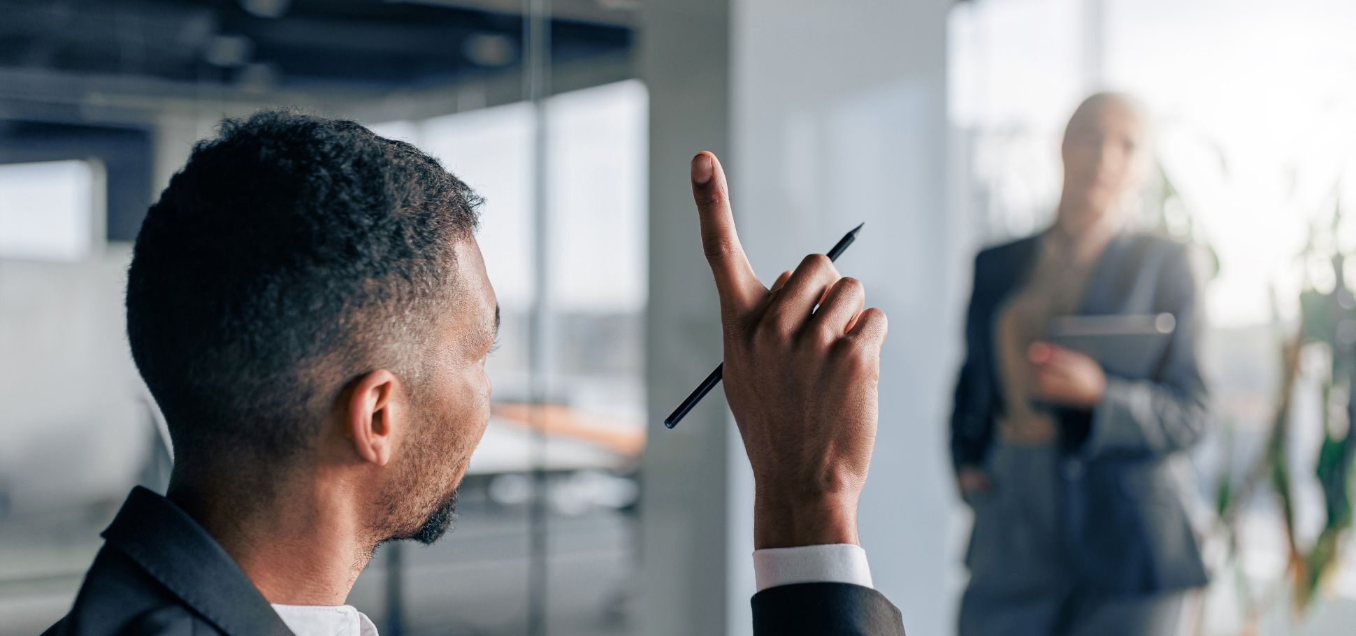 Man raises his hand in a conference room