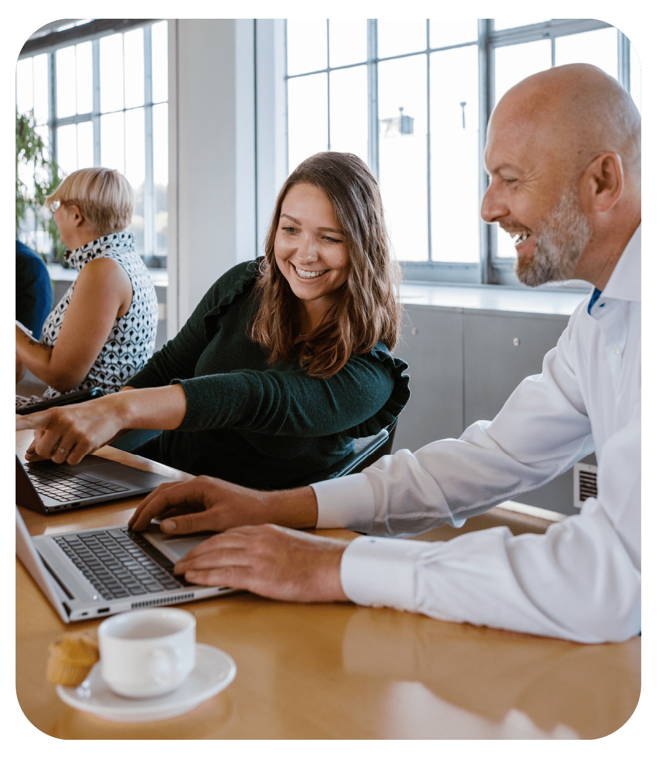 sana customer success team using laptops and pointing at screen smiling