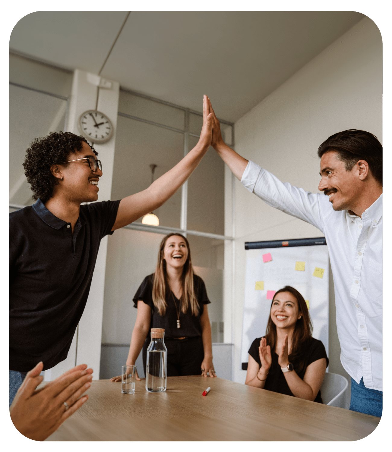 sana customer success team in a meeting high fiving over the table