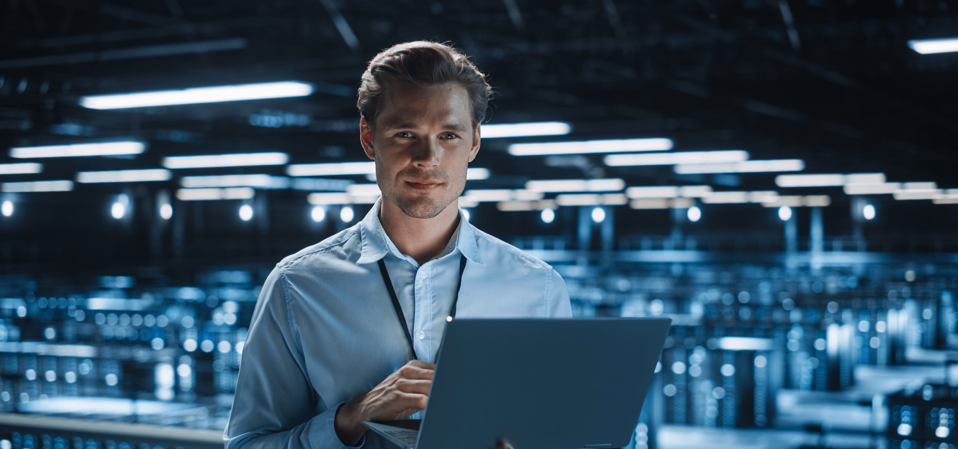 man holding laptop looking at camera